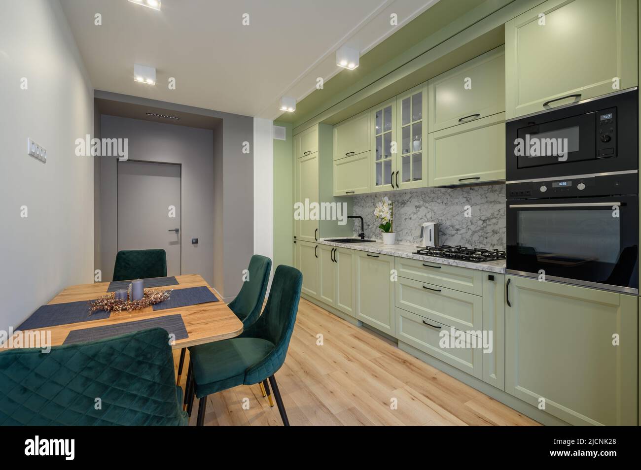 Moderne, hellgrüne, luxuriöse Küche mit Esstisch Stockfoto