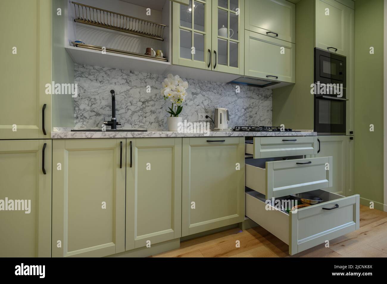 Moderne, hellgrüne, luxuriöse Küche mit Esstisch Stockfoto