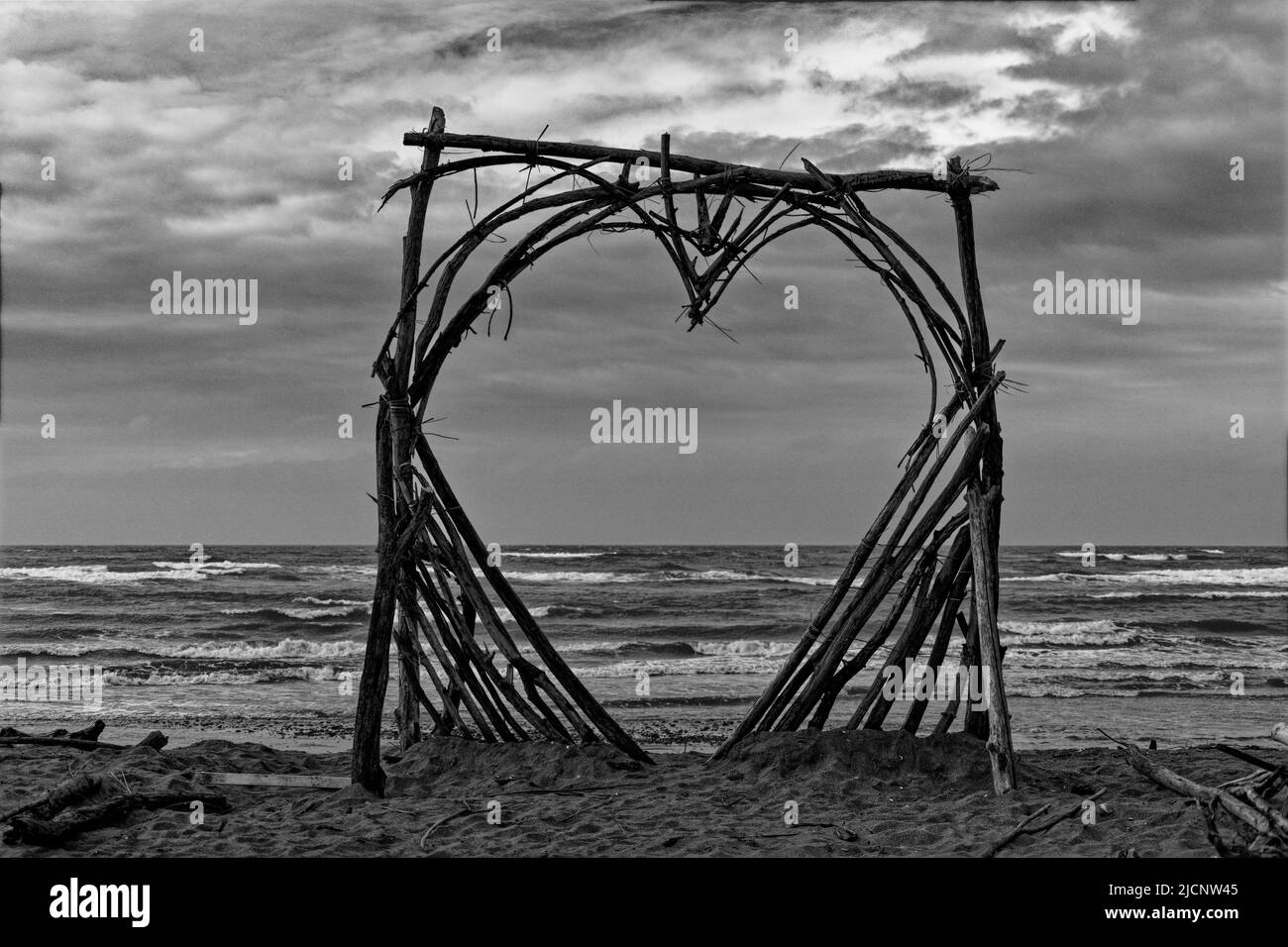 Eine monochrome Aufnahme eines Herzens aus Treibholz auf dem Motueka Sandspit, Tasmanische Region, Aotearoa / Neuseeland. Stockfoto