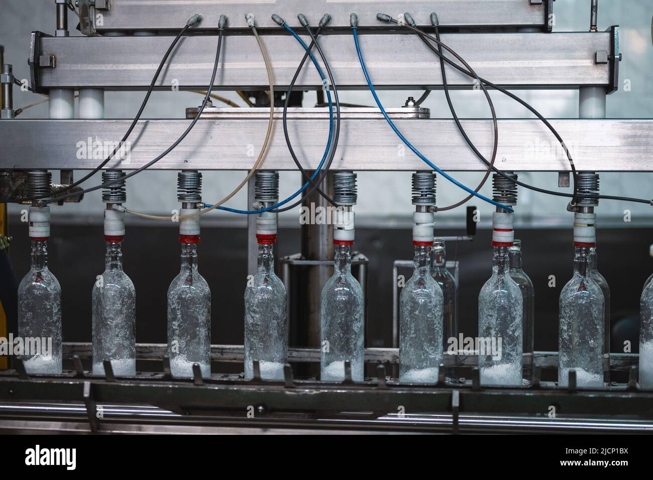 Füllen von Glasflaschen mit Wodka-Getränk auf der Produktionslinie Stockfoto