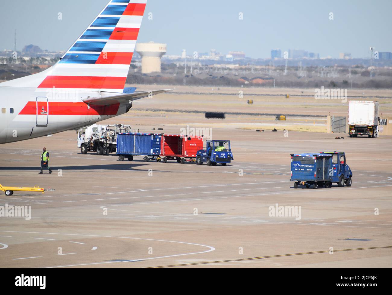 Ein Flugzeug von American Airlines, das von Ramp Service-Mitarbeitern außerhalb eines Terminals am DFW Airport (Dallas-Fort Worth Airport) bedient wird Stockfoto