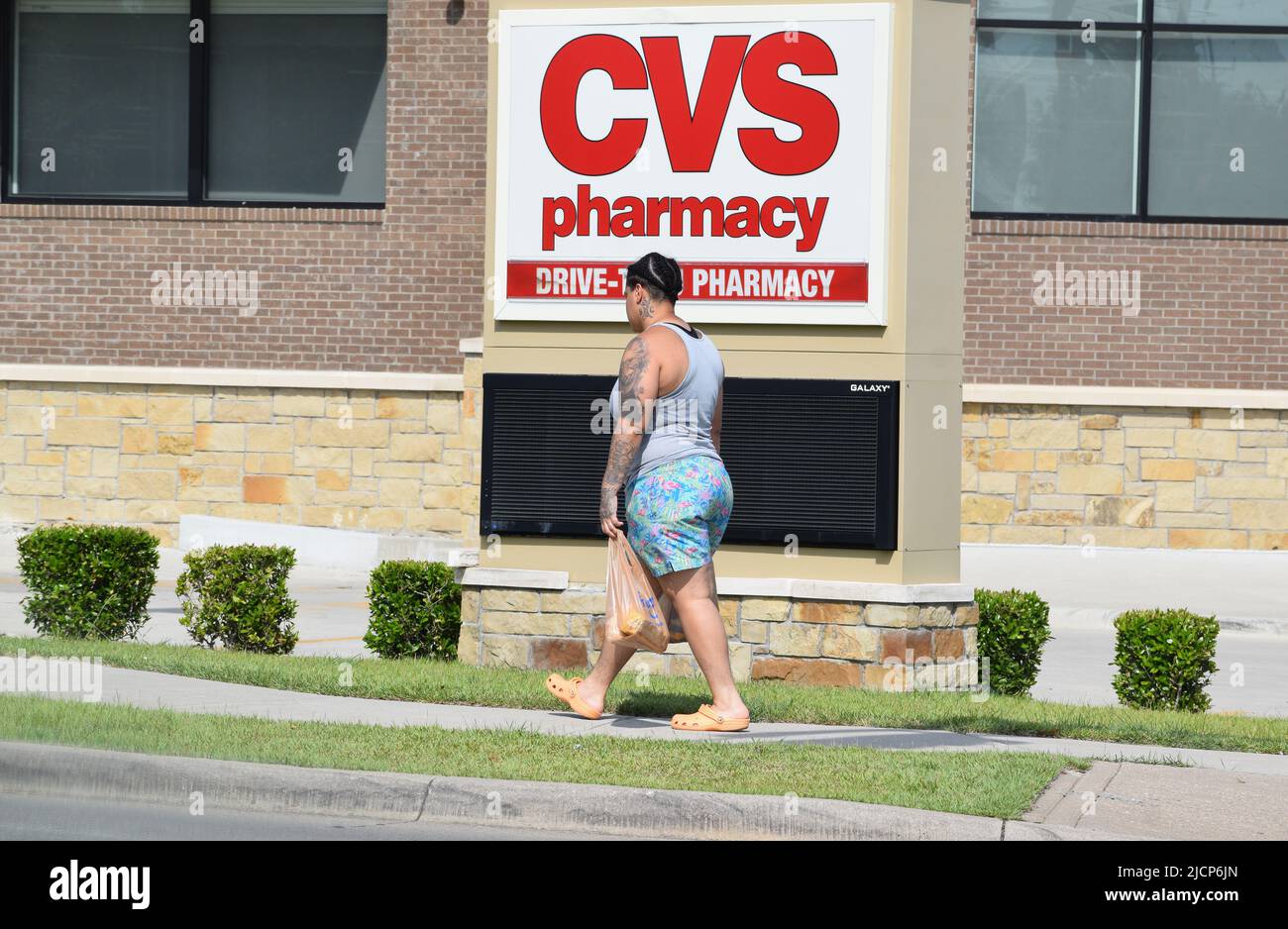 Afroamerikanische Frau, die vor einem CVS-Apothekenschild läuft Stockfoto