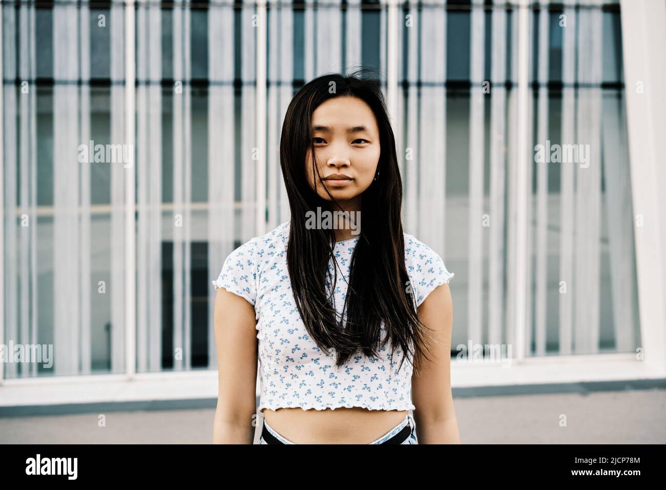 Porträt einer jungen asiatischen Frau, die im Freien auf die Kamera schaut. Stockfoto