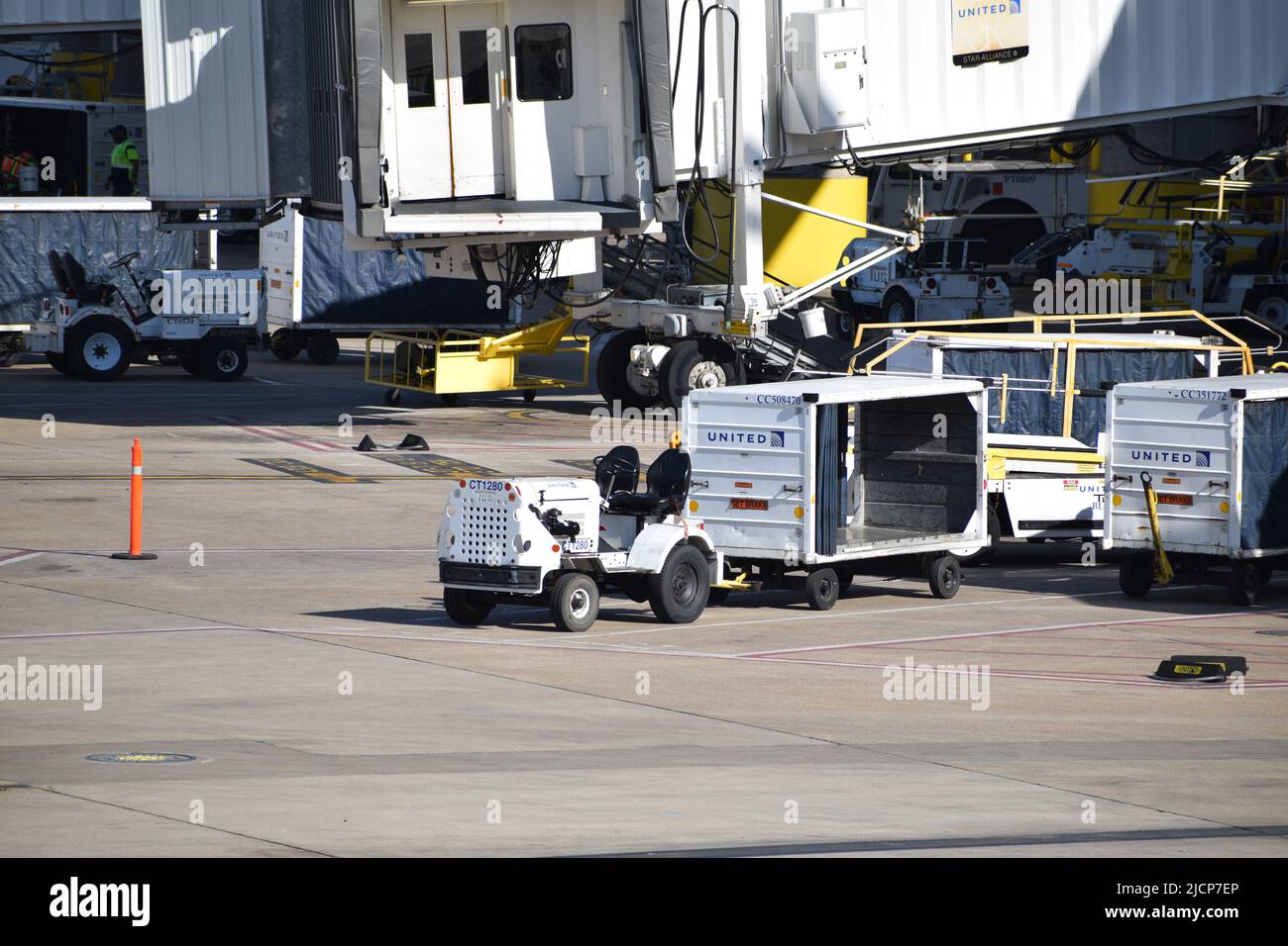 Traktor und leerer Gepäckwagen vor Terminal E am Dallas Fort Worth International Airport (DFW Airport) Stockfoto