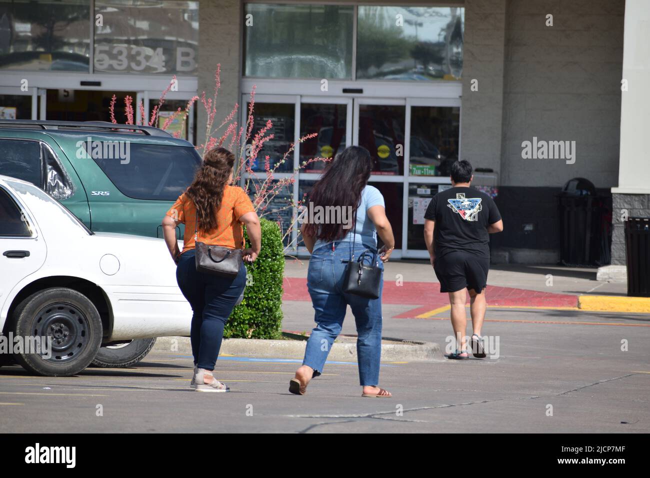 Einkäufer (eine übergewichtige hispanische Familie) auf einem Parkplatz, die zu einem Fiesta-Lebensmittelgeschäft in Dallas, Texas, laufen Stockfoto