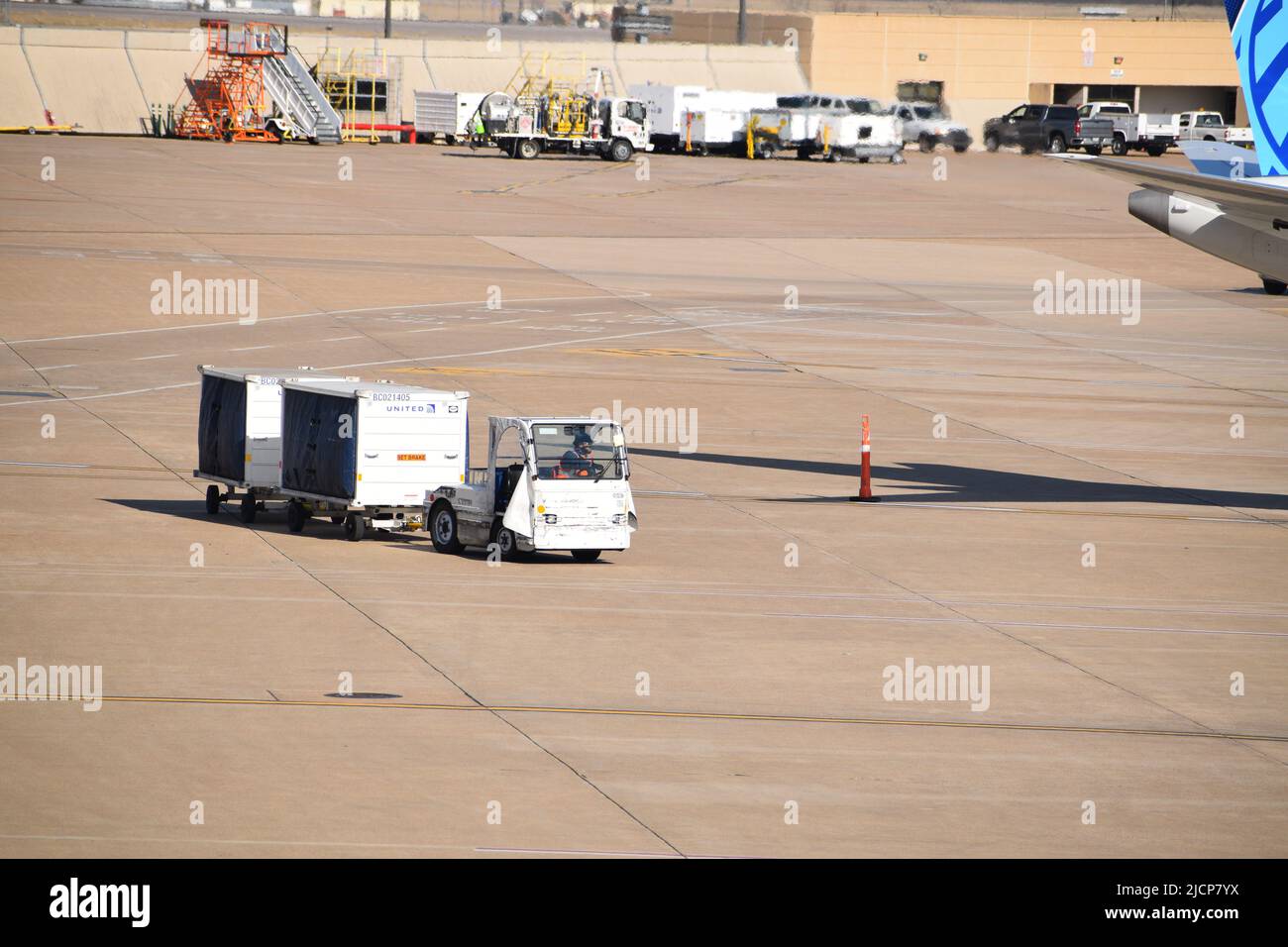 Ein Schlepper von United Airlines, der am Dallas-Fort Worth International Airport (DFW Airport) Gepäckwagen zum Terminal E zieht Stockfoto