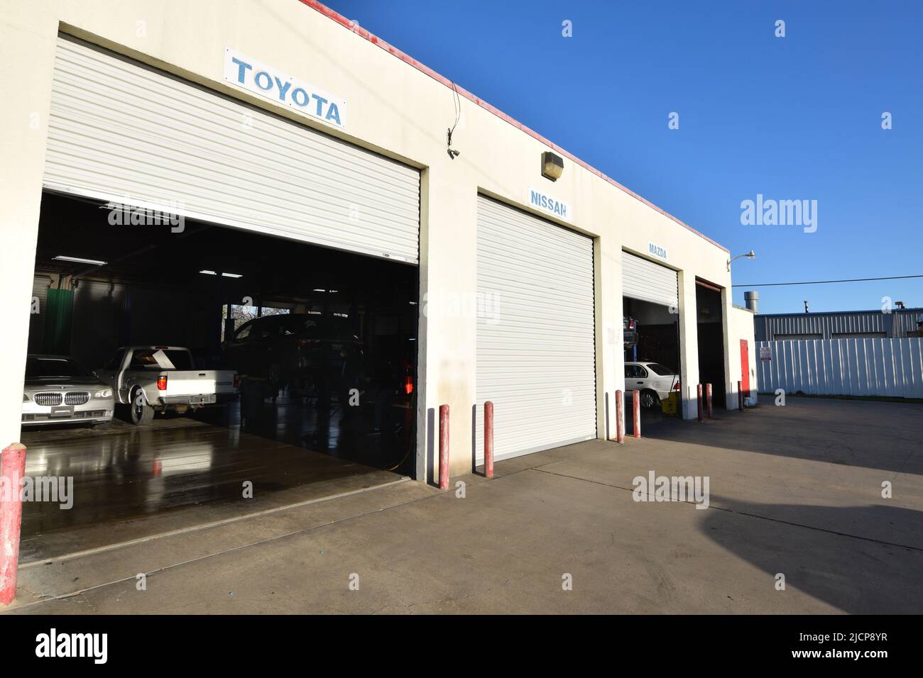 Autos, die in der Garage einer ausländischen Autowerkstatt geparkt sind Stockfoto
