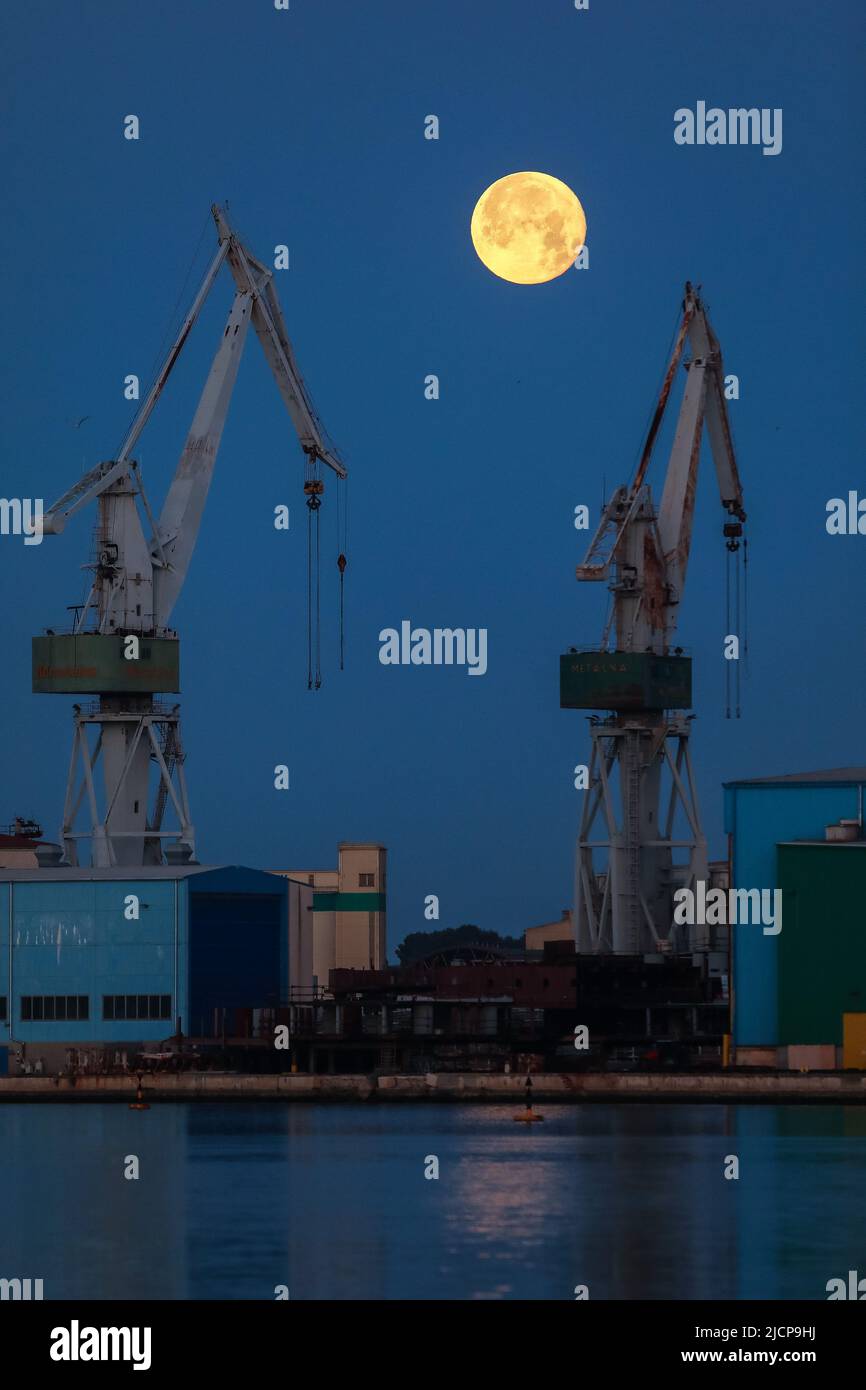 Am 15. Juni 2022 bricht bei der Werft Uljanik in Pula, Kroatien, der Vollmond der Erdbeere hinter Kraniche aus. Der Name stammt vom Algonquin-Stamm der Inder in Stockfoto