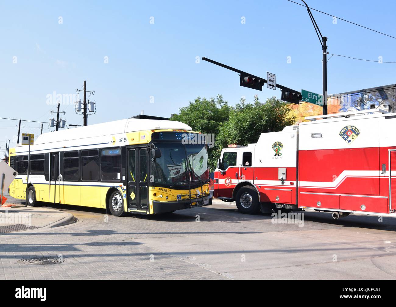 Feuerwehrauto der Stadt Dallas, das einen DART-Bus auf dem Malcolm X Boulevard und der Elm Street im Gebiet Deep Ellum passiert Stockfoto