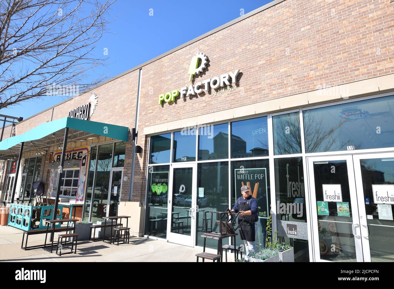 Ein Mann, der sich außerhalb eines Pop Factory-Stores in der Toyota Music Factory in Irving, Texas, zur Arbeit aufmacht Stockfoto