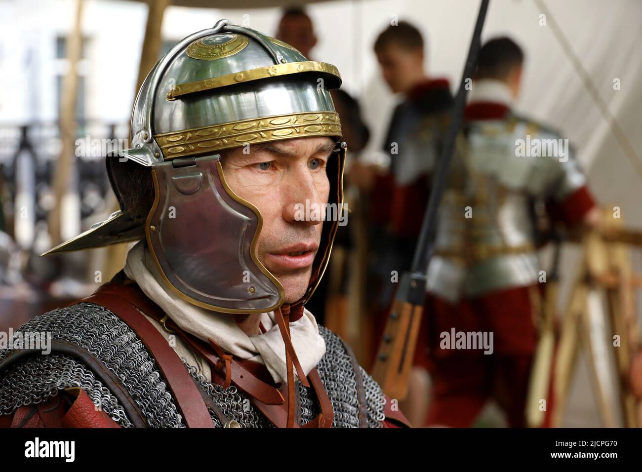 Soldat einer römischen Legion mit Legionären im Hintergrund während historischer Festzeiten und Epochen. Legionär im Lager, Armee des antiken Roms Stockfoto