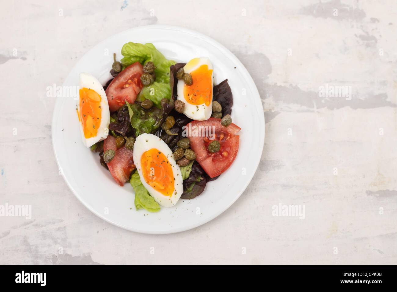 Frischer Gemüsesalat mit gekochtem Ei auf weißer Schale Stockfoto