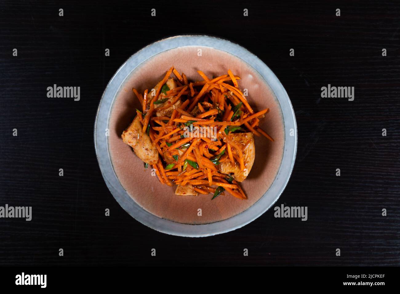 Geriebener Karottensalat mit Huhn, gehacktem Knoblauch-Schnittlauch und Salatöl Stockfoto