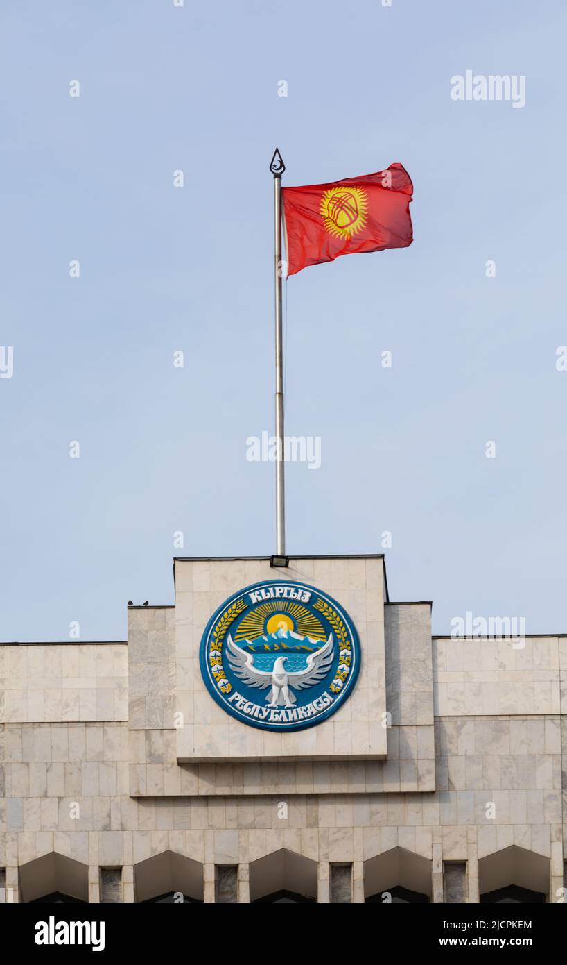 Bischkek, Kirgisistan - 21. Oktober 2021: Nationales Emblem und Flagge Kirgisistans auf dem Gebäude des Weißen Hauses Stockfoto