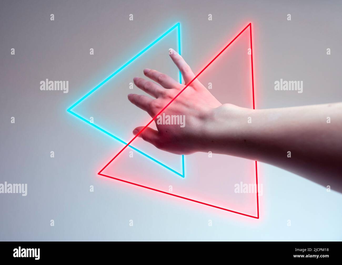 Hand, die in ein Neonlicht als Tor für Metaverse eintritt Stockfoto