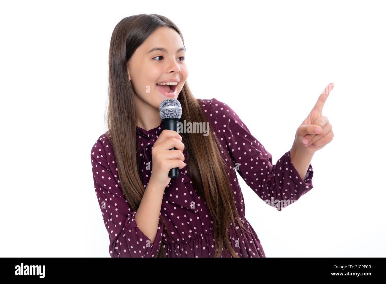 Hübsches kleines Mädchen, das mit dem Mikrofon singt. Porträt der emotionalen erstaunt aufgeregt Teenager-Mädchen. Stockfoto