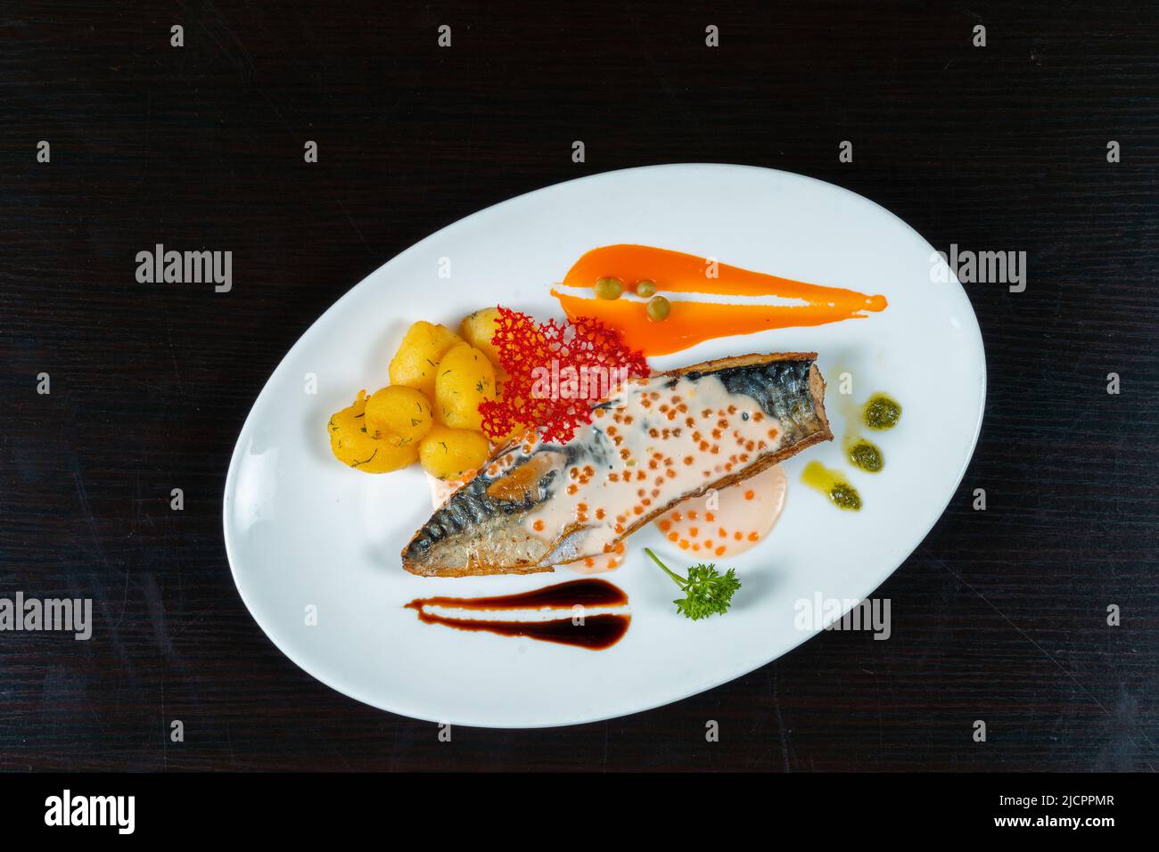 Gegrillter Speer mit Kartoffeln und verschiedenen Saucen auf schwarzem Hintergrund Stockfoto