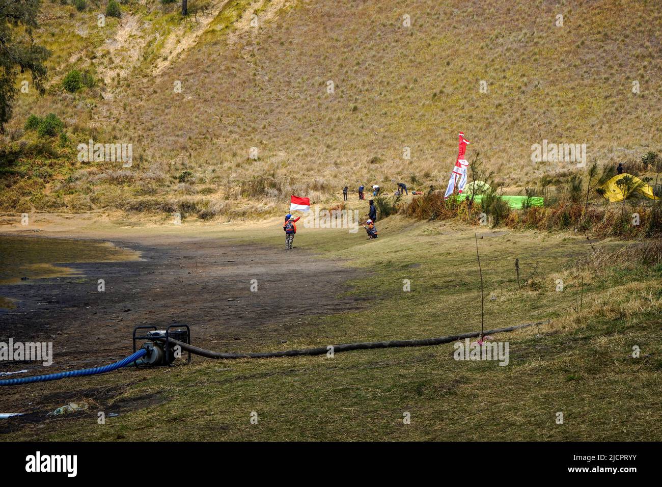 Junger Mann mit indonesischer Flagge auf dem Campingplatz Kumbolo Stockfoto