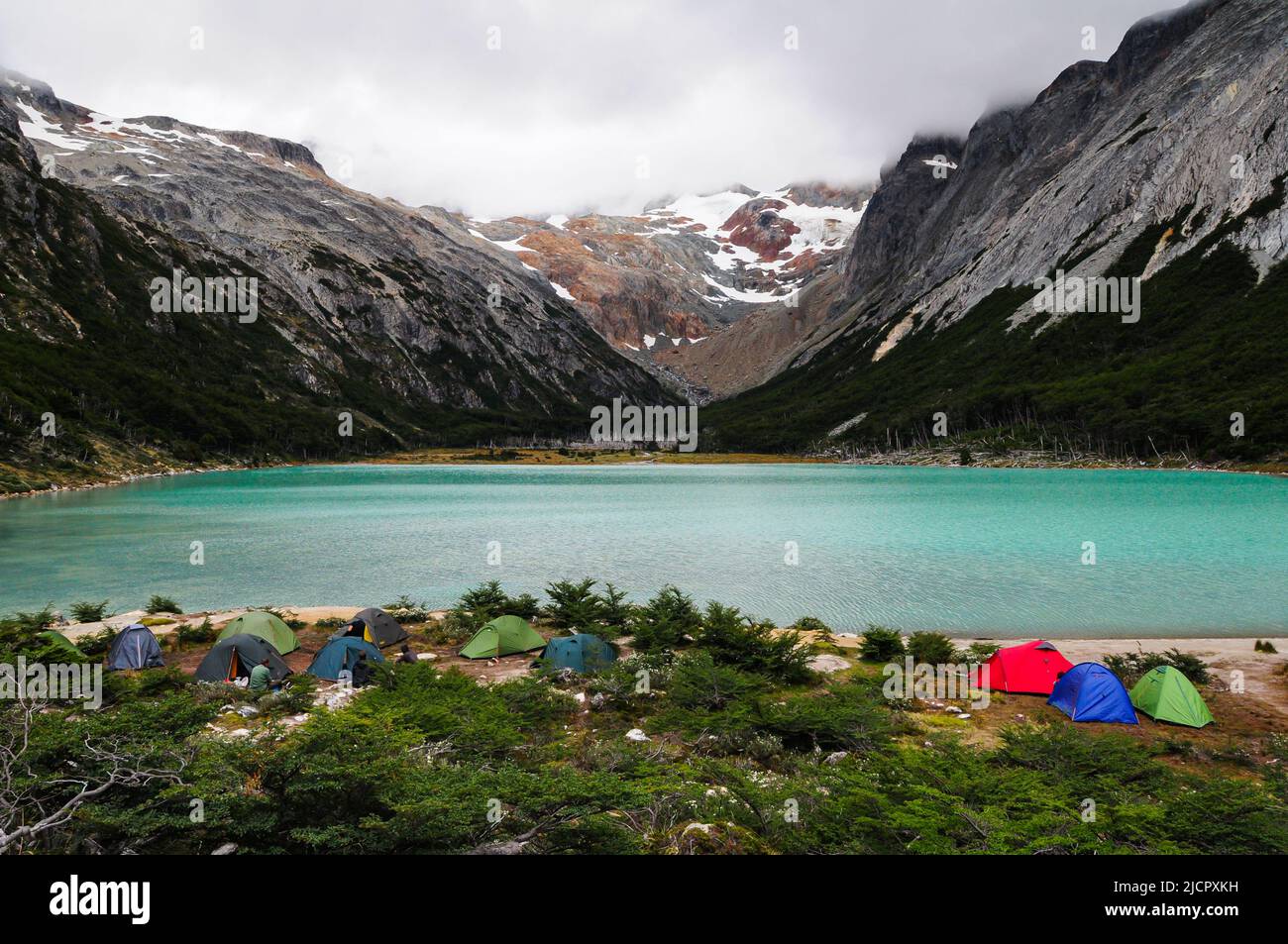Gruppe von Leuten, die mit Zelten in der Nähe des Bergsees campen Stockfoto