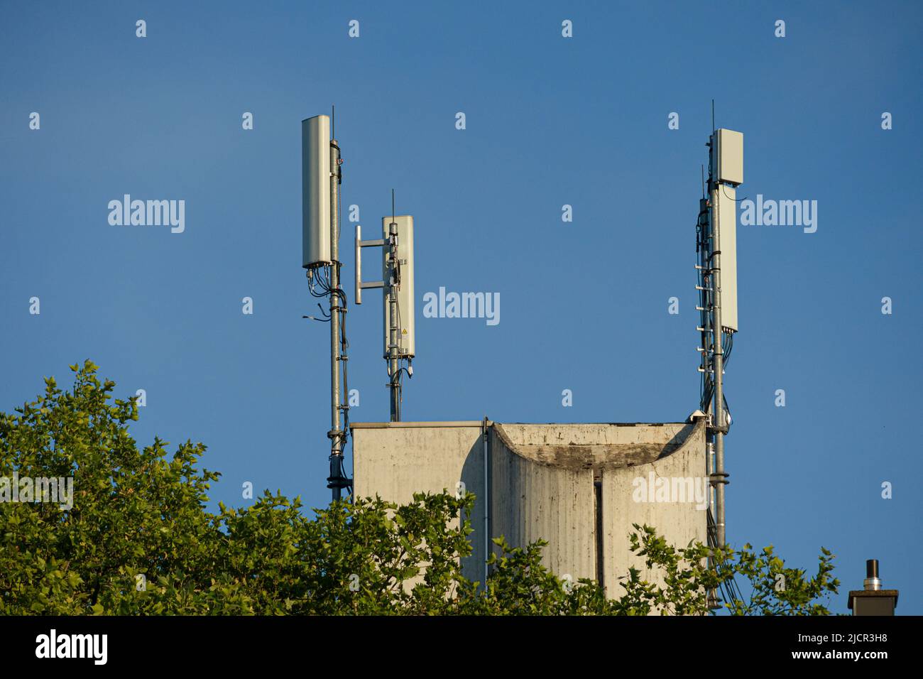 Drei Antennenmasten für den Mobilfunk auf einem Dach Stockfoto