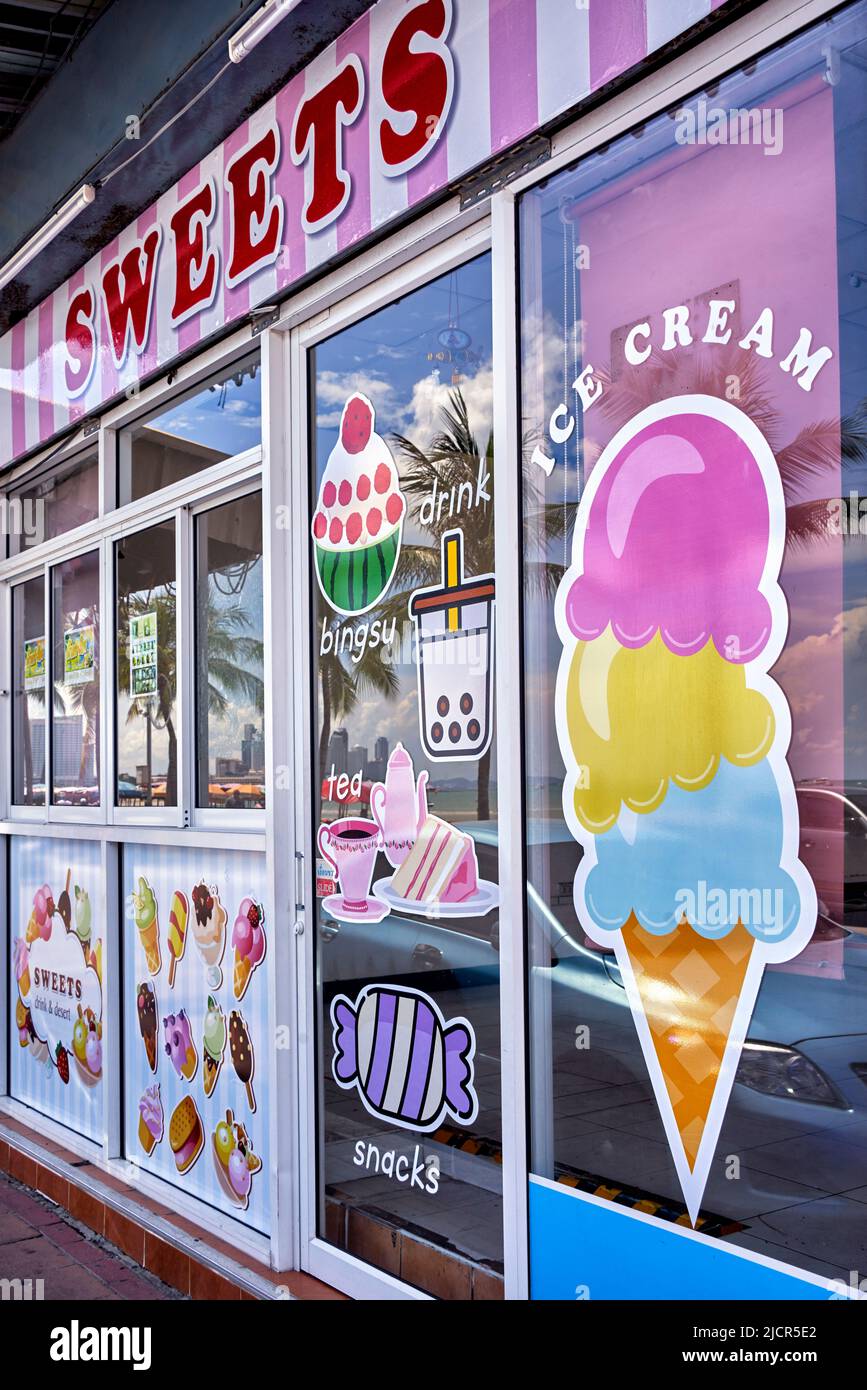 Eiscafé-Fenster und Süßwaren-Süßwarenladen vorne mit farbenfroher Fensterdekoration. Stockfoto