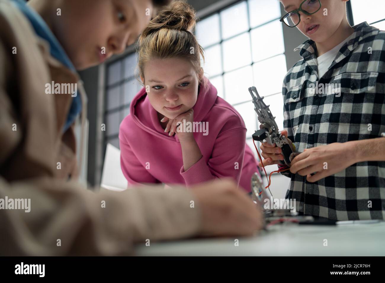 Eine Gruppe von Kindern, die zusammen an einem Projekt mit elektrischen Spielzeugen und Robotern im Roboterunterricht arbeiten, Nahaufnahme für Mädchen Stockfoto