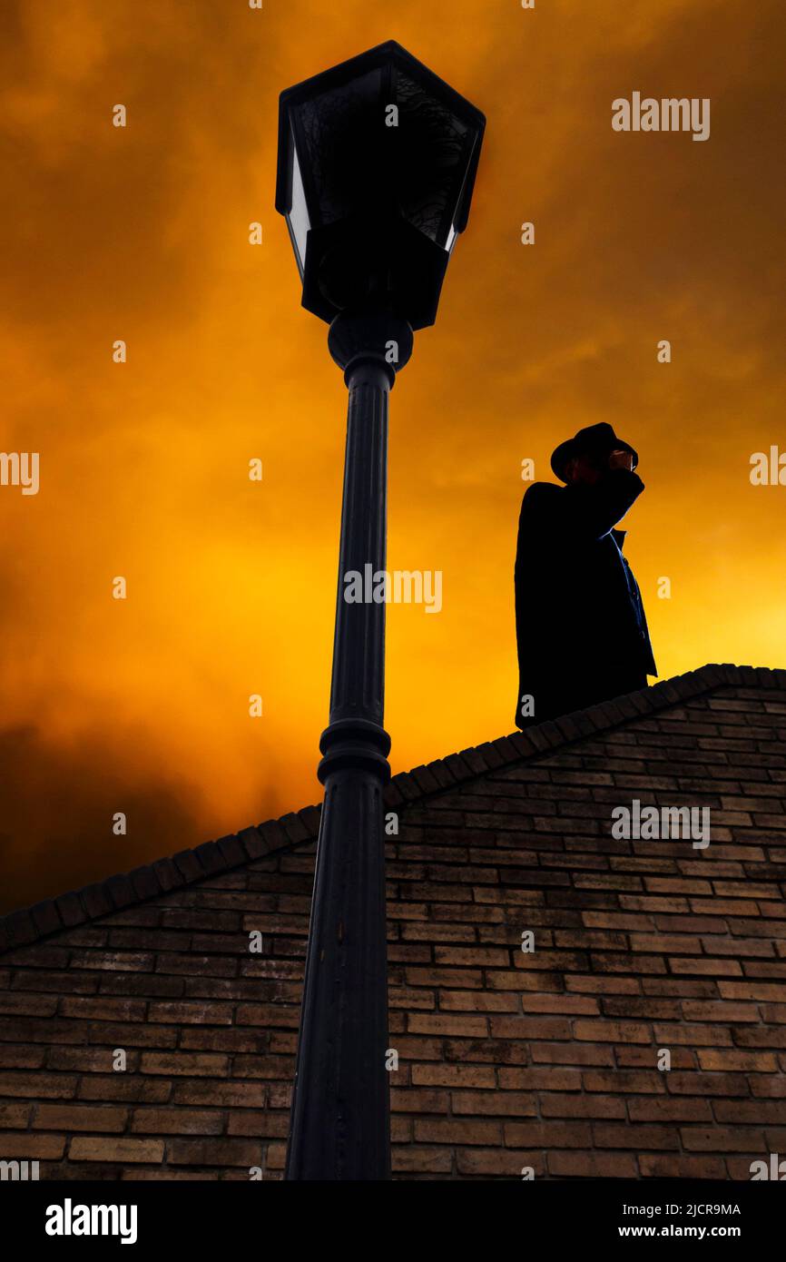Mysteriöser Mann mit Fedora-Hut, der oben steht Stockfoto