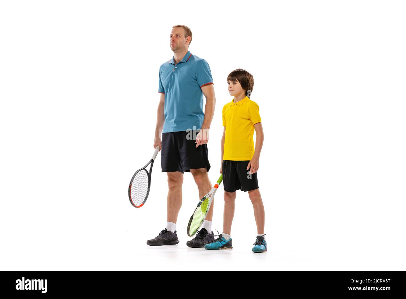 Professioneller Tennisspieler, Trainer und Junge im Schulalter in Sportuniform, die isoliert auf weißem Hintergrund zusammenstehen. Konzept des Sports Stockfoto