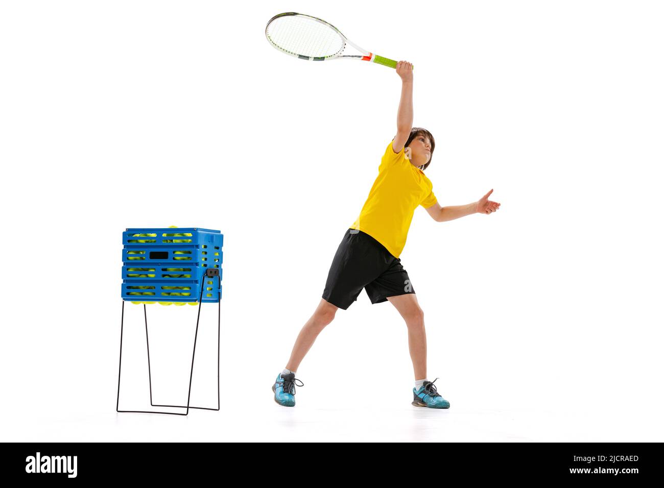 Dynamisches Porträt eines Jugendlichen, sportlichen Kindes, das Tennis spielt, isoliert auf weißem Studiohintergrund. Konzept von Sport, Leistungen, Hobby, Können Stockfoto