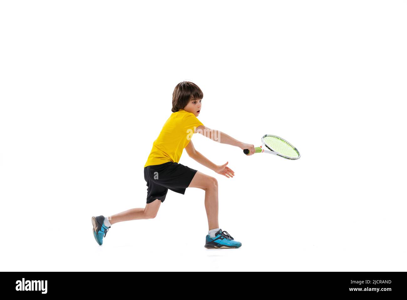Dynamisches Porträt eines Jugendlichen, sportlichen Kindes, das Tennis spielt, isoliert auf weißem Studiohintergrund. Konzept von Sport, Leistungen, Hobby, Können Stockfoto
