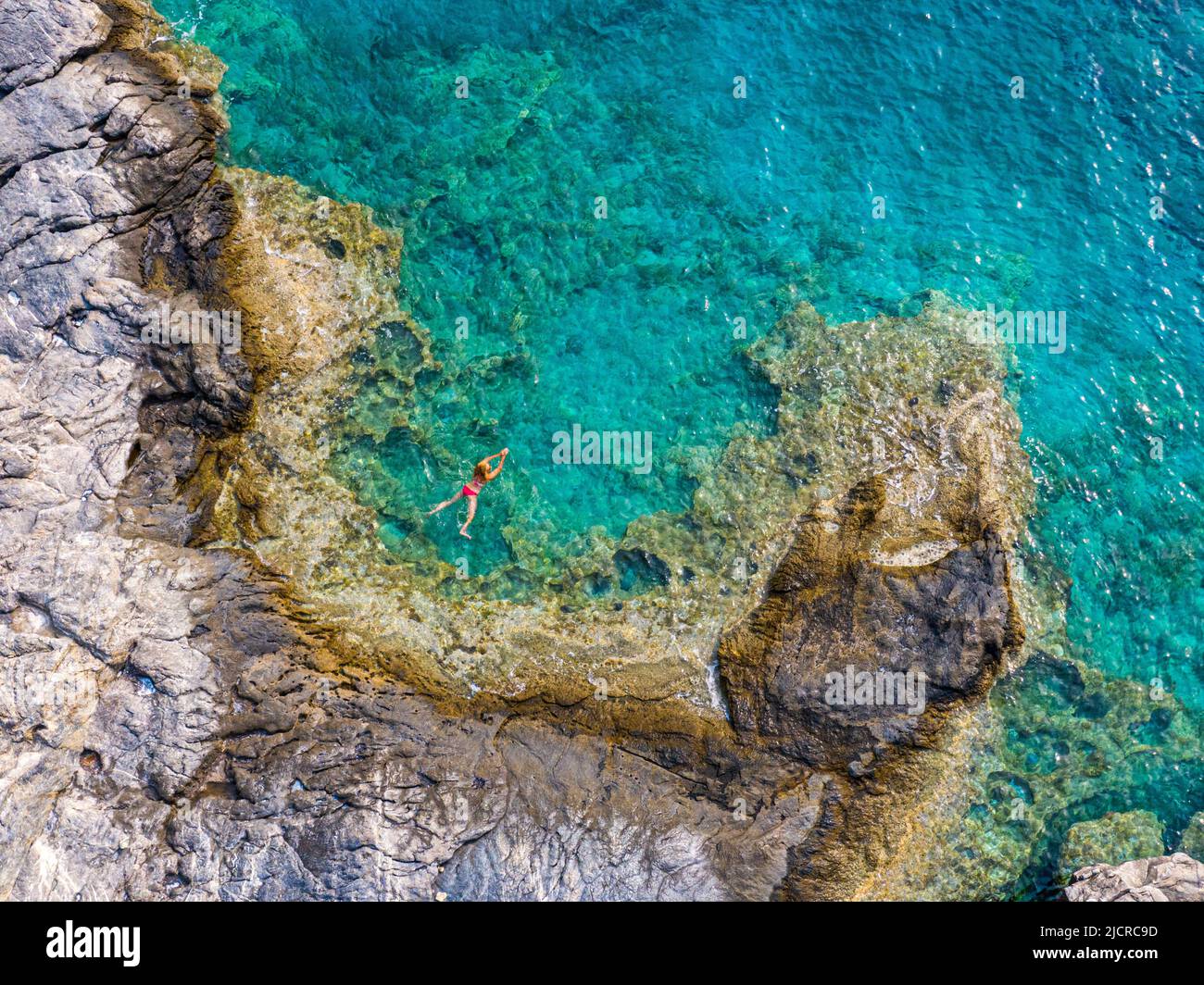 Luftaufnahme der transparenten Meeresoberfläche mit nicht erkennbaren Menschen, die im Meer schwimmen, Amorgos, griechenland Stockfoto