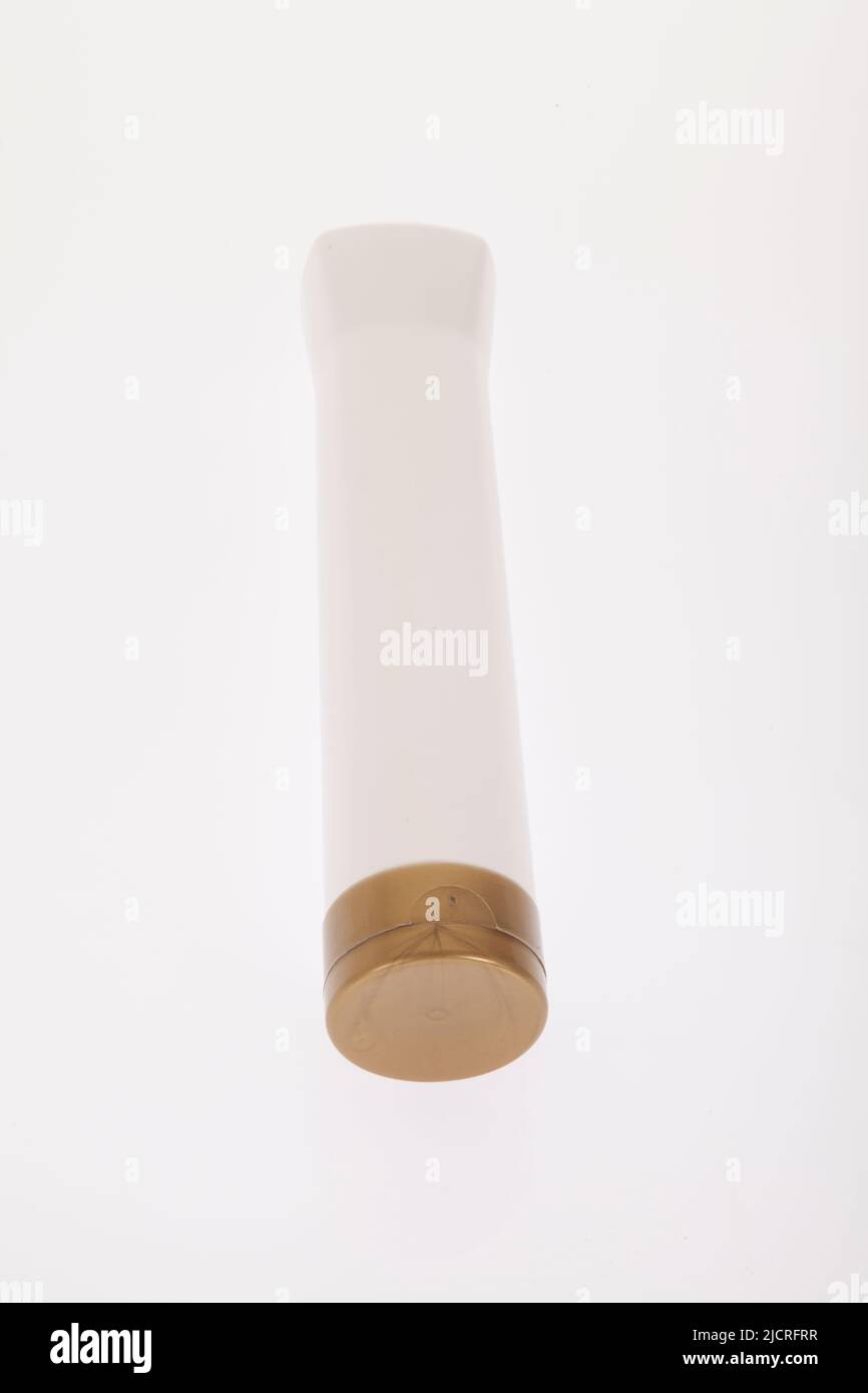 Mehrzweckbehälter; weißes Kunststoffglas mit goldenem Deckel - Foto auf weißem Hintergrund. Stockfoto
