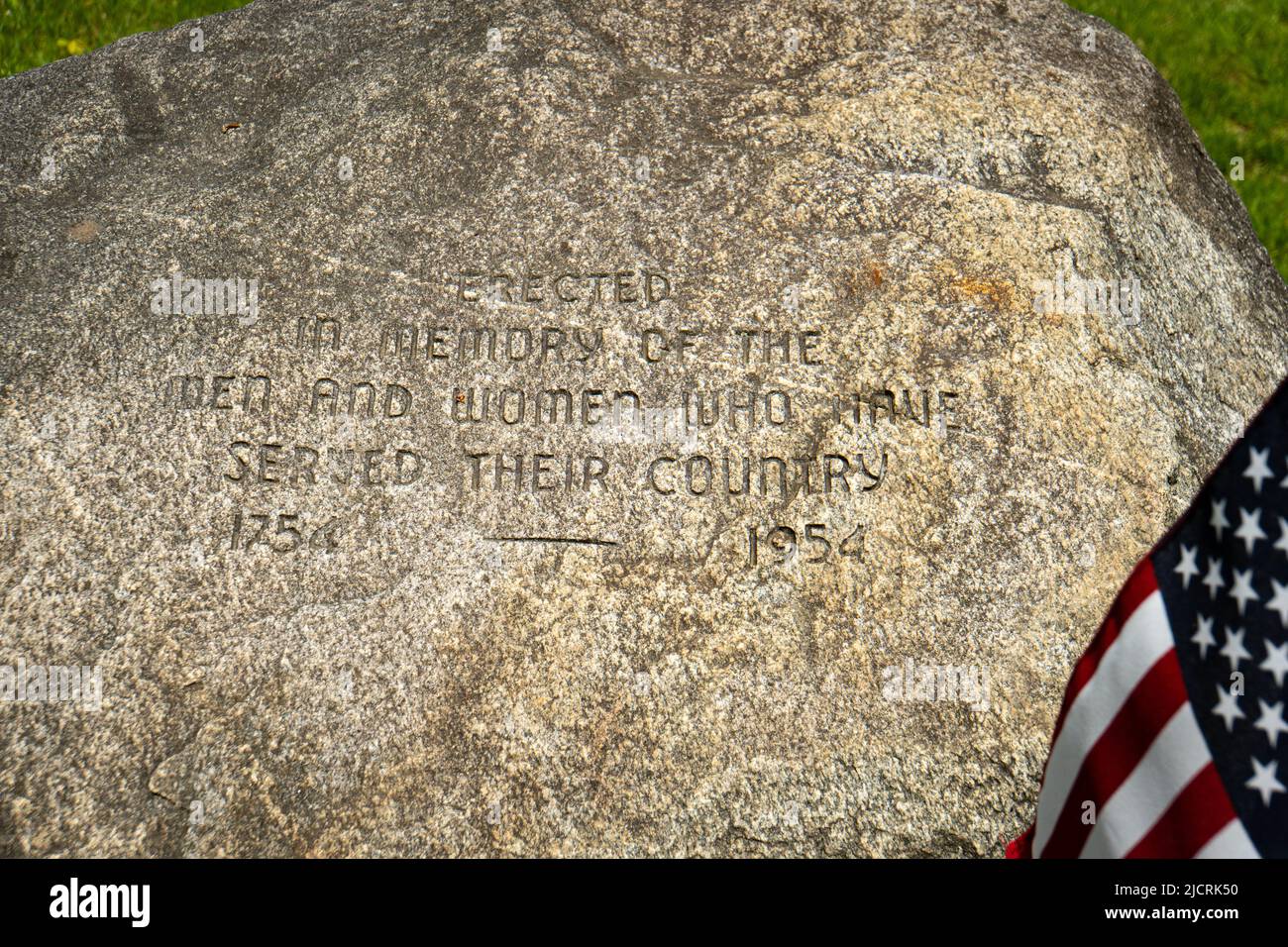 Amerikanische Flagge und Stein "errichtet in Erinnerung an die Männer und Frauen, die ihrem Land 1754 bis 1954 gedient haben" auf einem New England Dorf grün Stockfoto