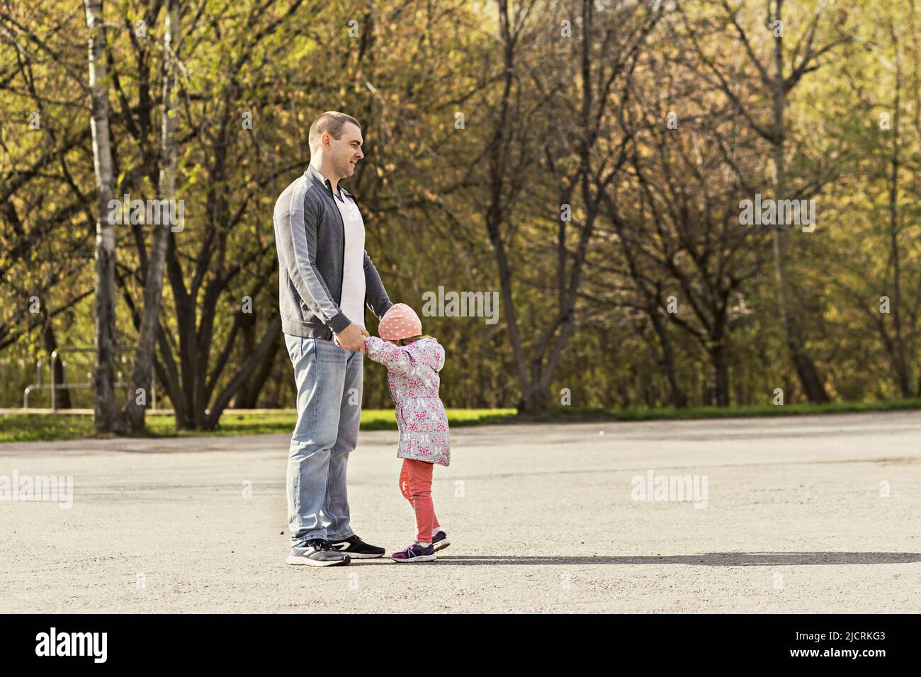 Papa spielt mit seinen Töchtern im Park. Ein Mädchen herumwirbeln. Familie. Stockfoto