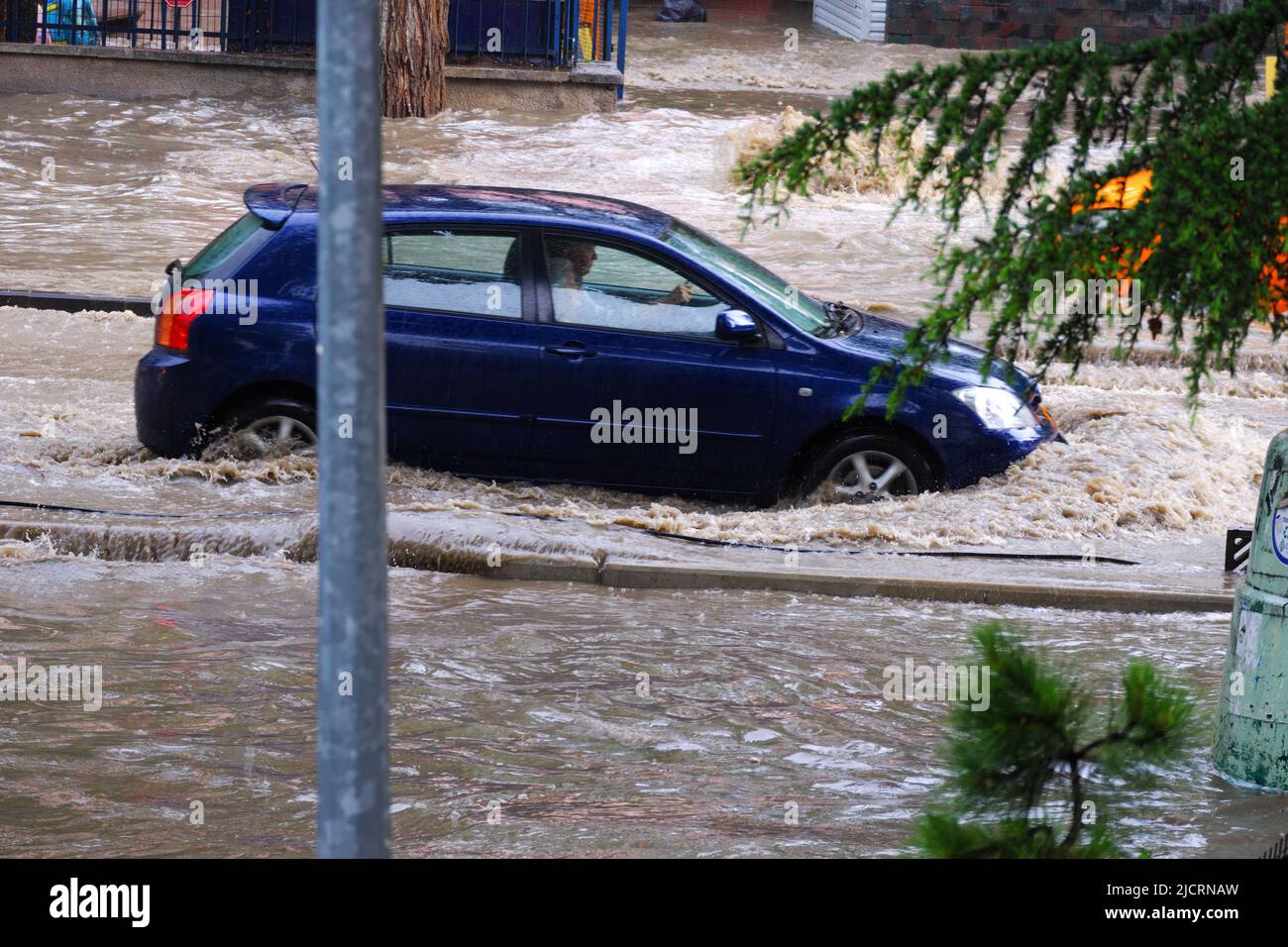 Auto bewegt sich auf überfluteter Straße Stockfoto