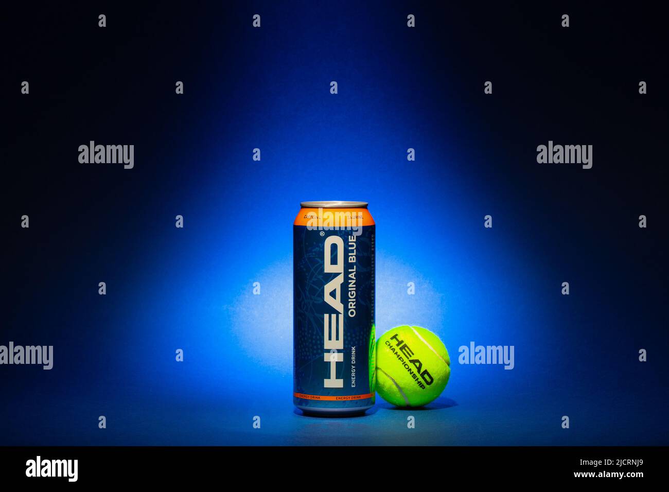 Prag, Tschechische Republik - 19, Mai 2022: HEAD Energy Drink und gelber Tennisball auf blauem Hintergrund. HEAD Energy Drinks enthalten Koffein und Taurin Stockfoto