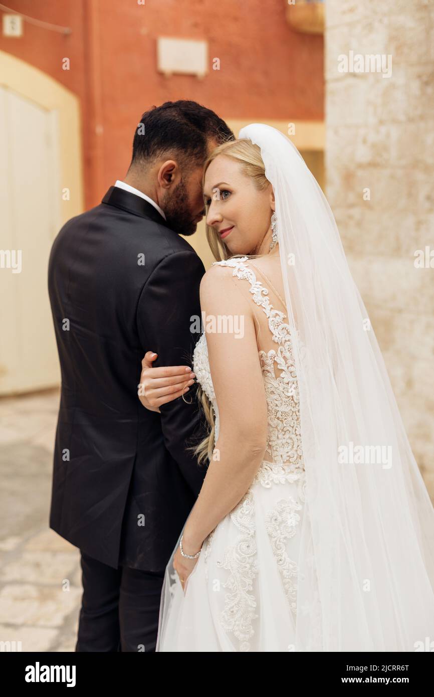 Vertikales Porträt eines romantischen Ehepaares, nach der Hochzeit, überkleidet, draußen stehen. Italien Urlaub, Reise ins Ausland Stockfoto
