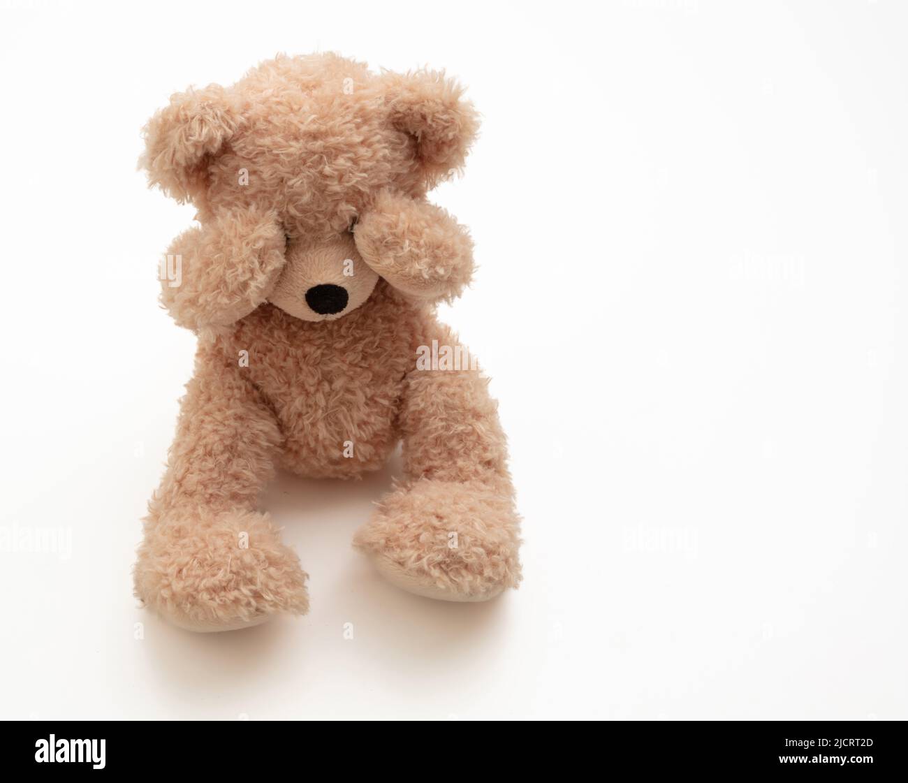 Konzept für Kindesmissbrauch. Teddybär-Deckelauge isoliert auf weißem Hintergrund, Vorderansicht Stockfoto