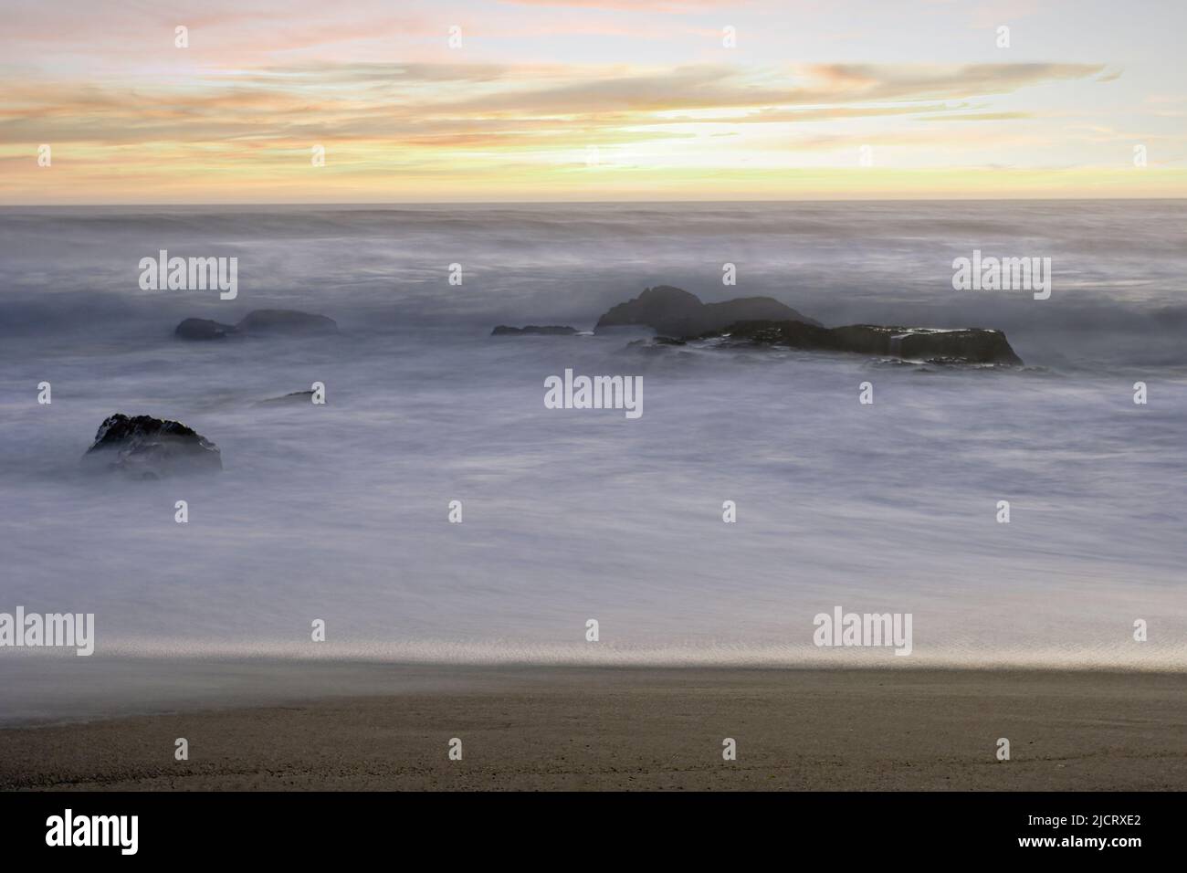 Nördlicher portugiesischer felsiger Strand bei Sonnenuntergang oder Dämmerung. Langzeitbelichtung. Stockfoto