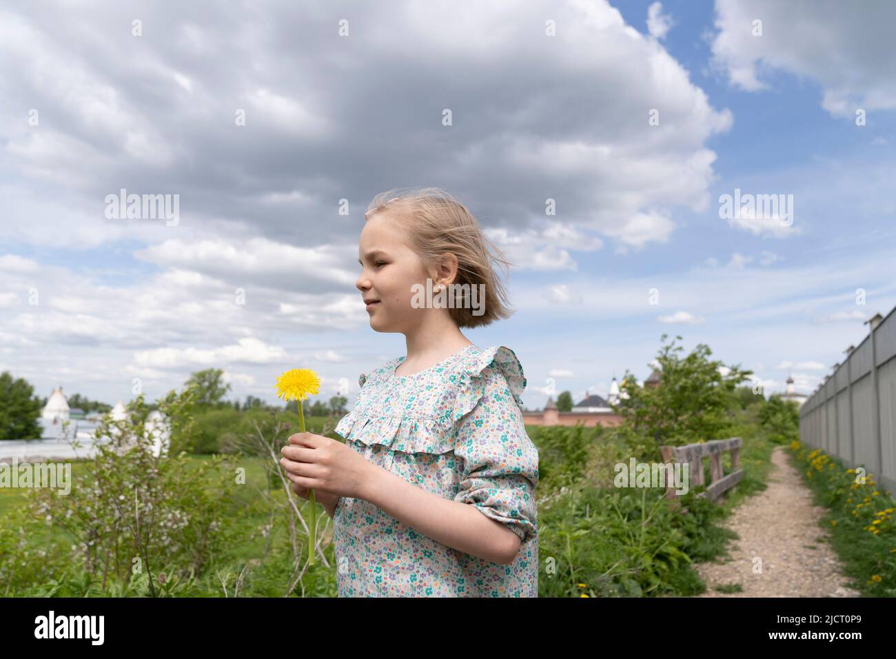 Porträt eines niedlichen 8-jährigen Mädchens mit einem Dandelion. Stockfoto