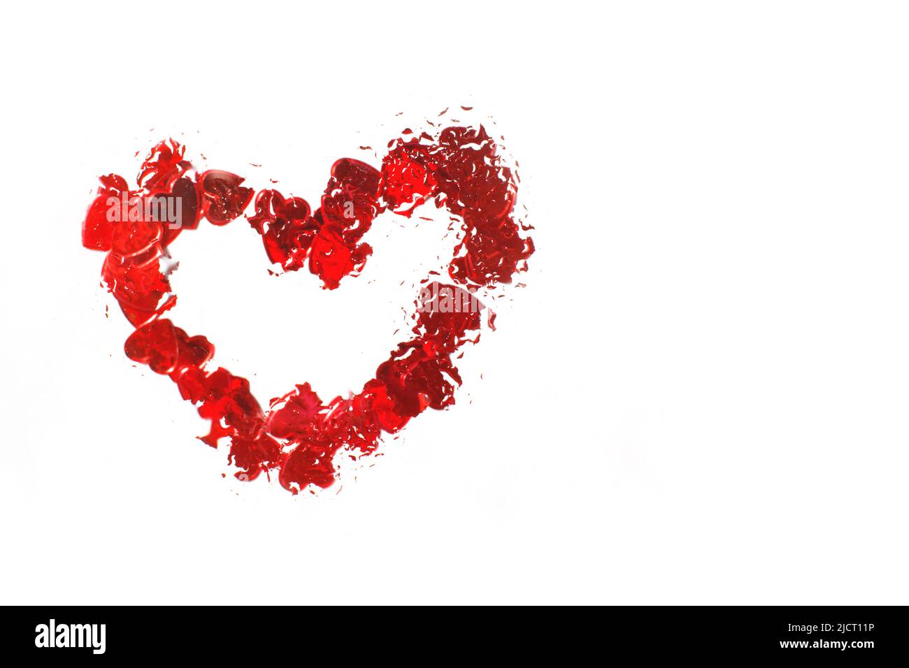Rotes Herz unter Glas mit Wassertropfen. Abstrakter Hintergrund mit Wassertropfen und bemaltem Herz auf der Oberfläche. Valentinstag Hintergrund, Liebe, Datum Co Stockfoto