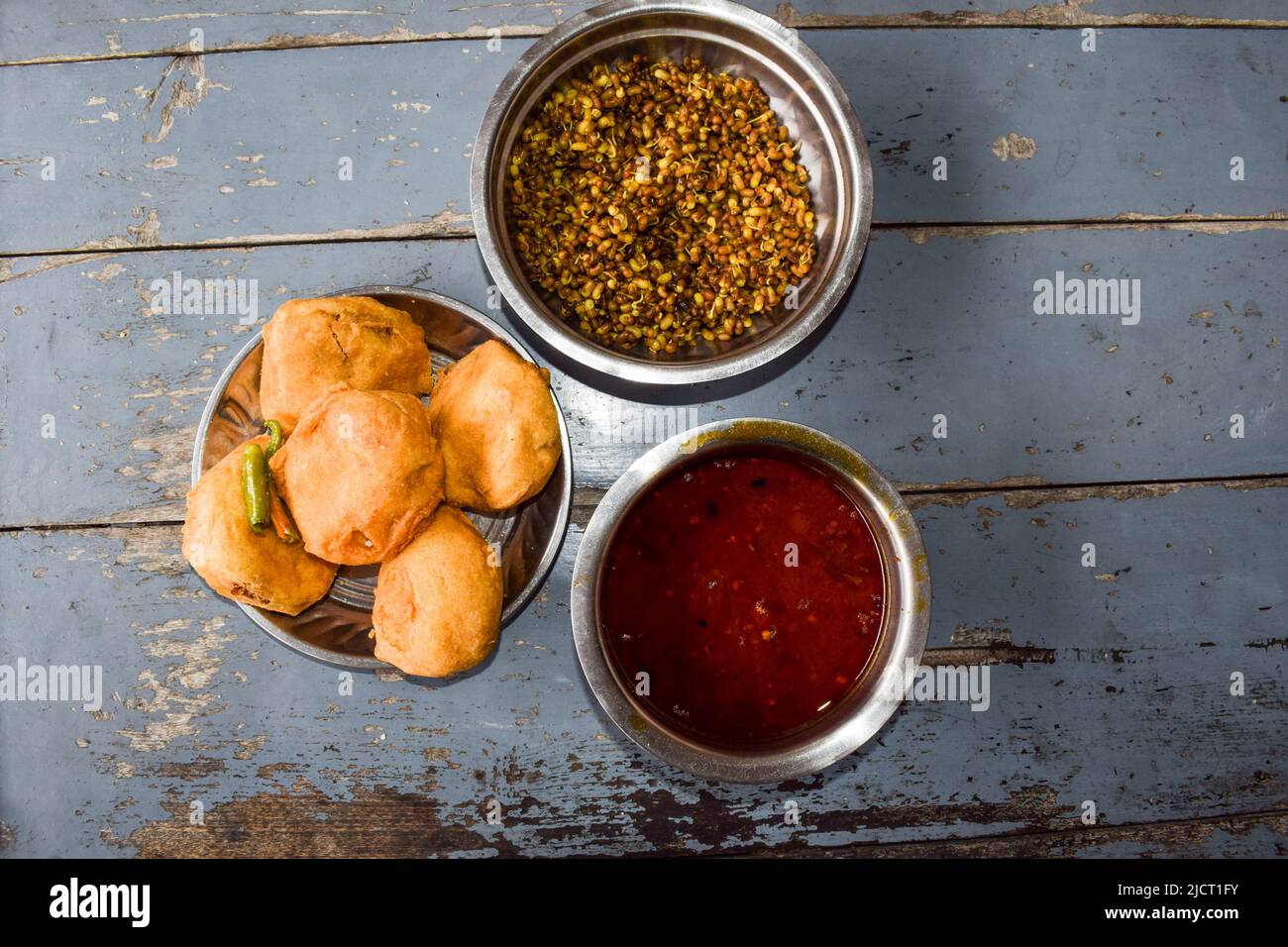 Aloo Batata Vada ist beliebtes Mumbai Essen, Maharastrian Street Essen gegessen mit rassa und gekeimt serviert mit ganz grün kühl und ussal Stockfoto