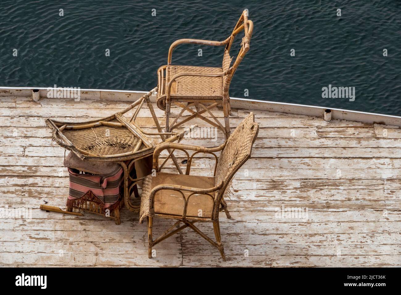 Kaputte, gut benutzte Rohrmöbel auf dem Oberdeck einer Nilfähre Stockfoto
