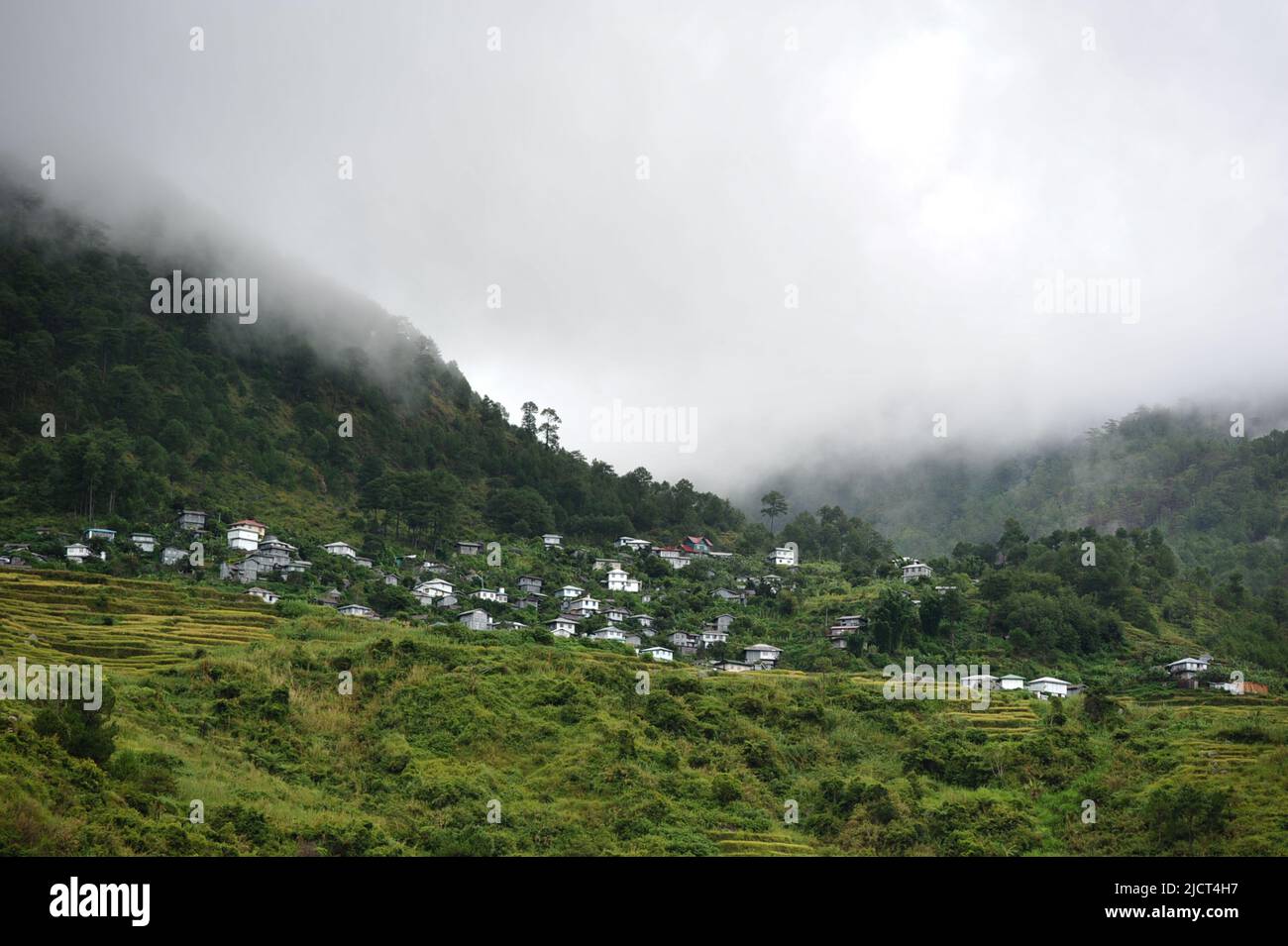 Mountain Province, Philippinen: Ätherische Sagada-Landschaft einer abgelegenen Gemeinde auf einem Berg, der an einem düsteren Tag im Nebel gehüllt ist. Stockfoto