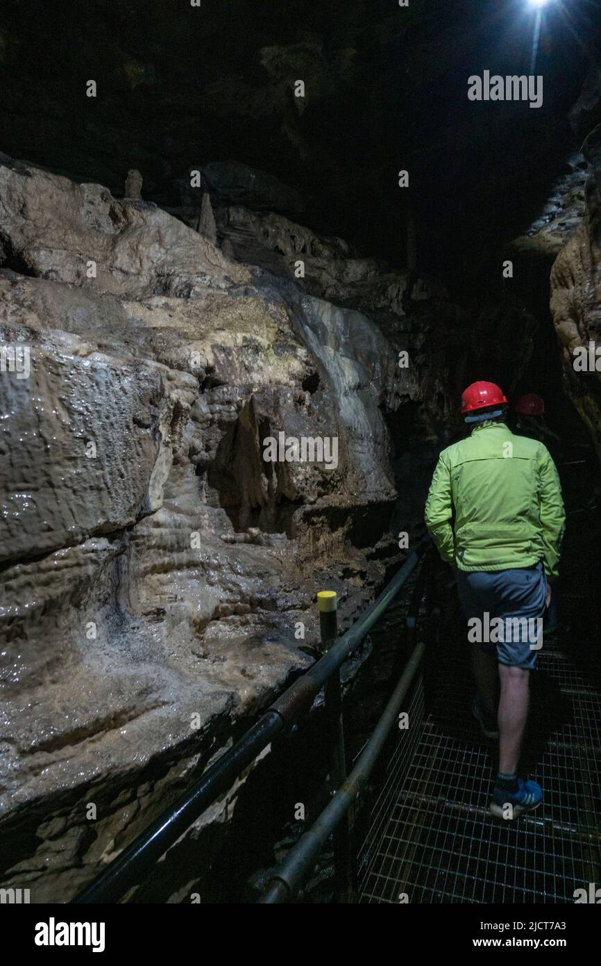 Besucher in Hartmützen in den atemberaubenden White Scar Caves in Ingleton, North Yorkshire, England. Stockfoto