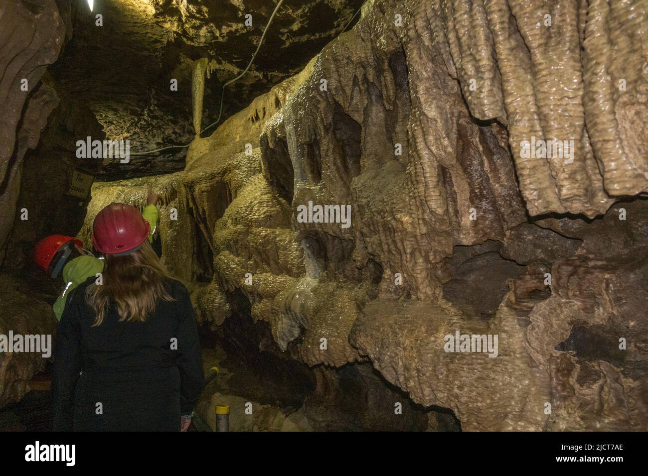Besucher in Hartmützen in den atemberaubenden White Scar Caves in Ingleton, North Yorkshire, England. Stockfoto