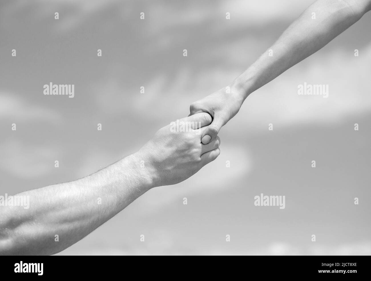 Eine helfende Hand geben. Hände von Mann und Frau, die sich gegenseitig erreichen, unterstützen. Solidarität, Mitgefühl und Nächstenliebe, Rettung. Eine helfende Hand geben Stockfoto