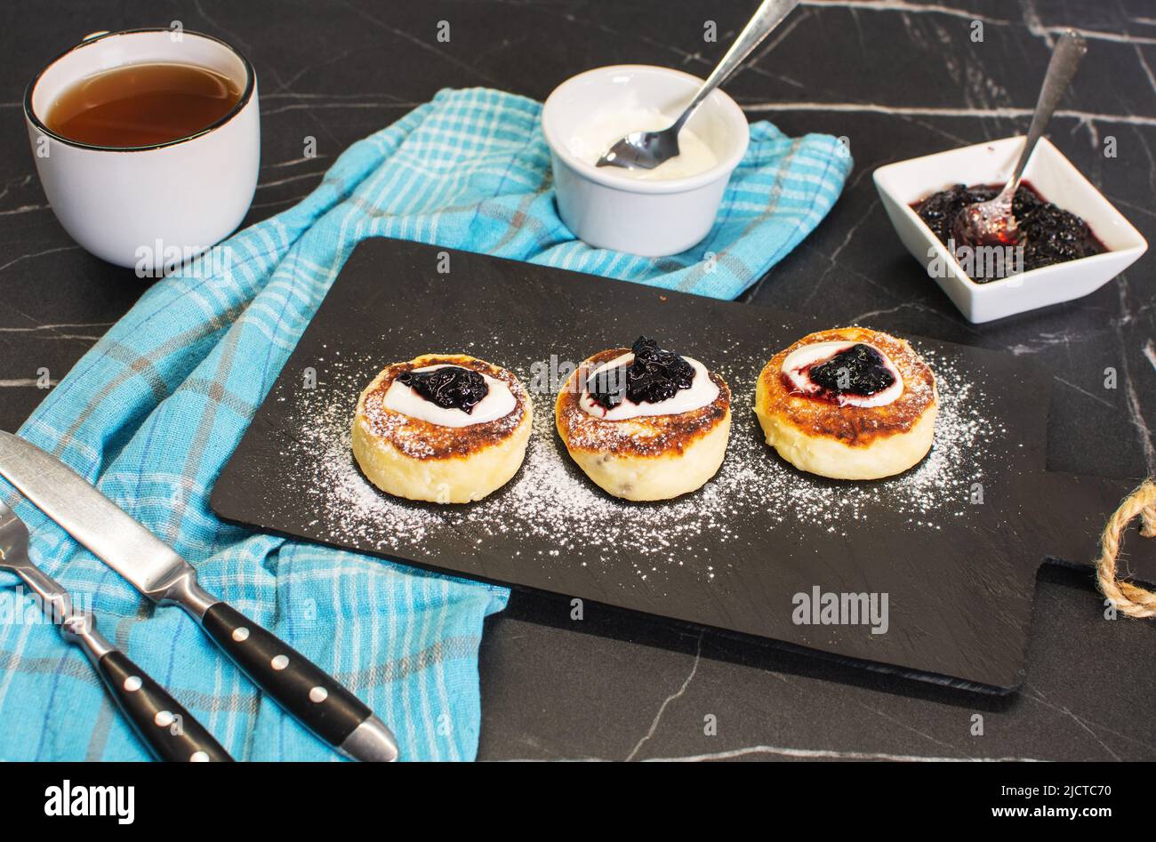 Süße Käsepfannkuchen auf dem Teller servierten Erdbeeren. Syrniki, Ricotta-Krapfen, Quark-Krapfen. Stockfoto