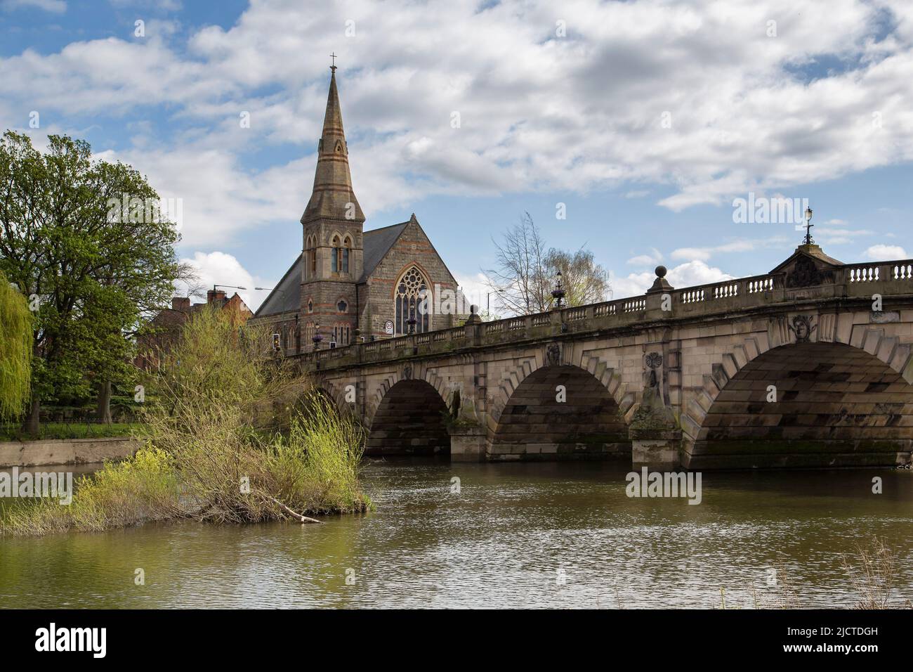 Eine mehrbogenige Straßenbrücke über den Fluss Severn in Shrewsbury, England. Auf der anderen Seite ist die Shrewsbury United Reform Church zu sehen. Stockfoto