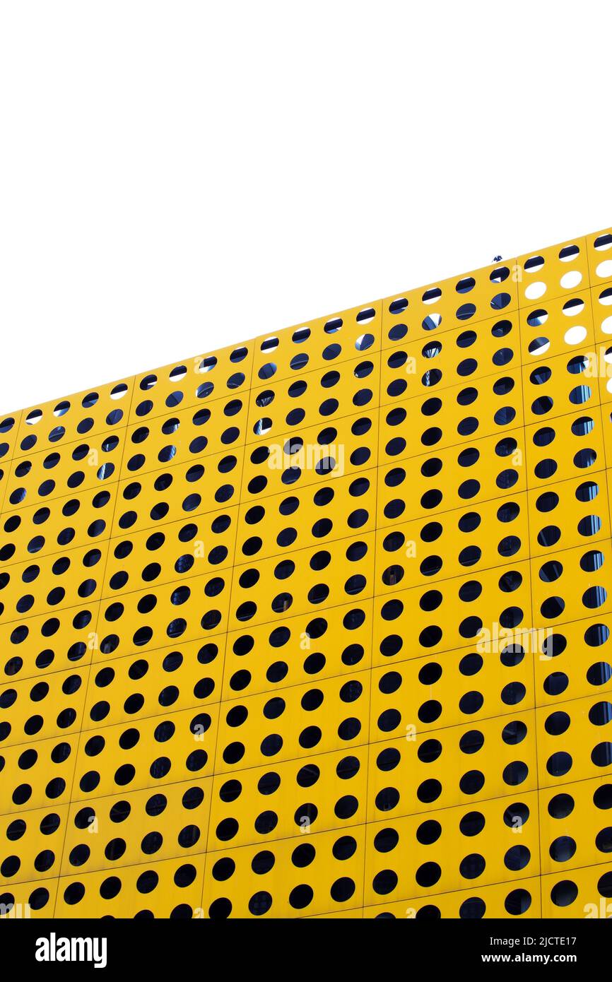 Gelbe Metalloberfläche mit kreisförmigen Perforationen Stockfoto